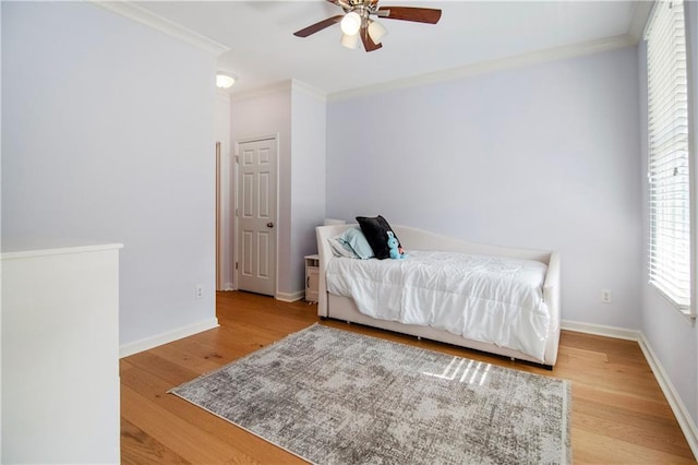 bedroom featuring ceiling fan, crown molding, and hardwood / wood-style flooring