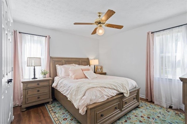 bedroom featuring a textured ceiling, a ceiling fan, and dark wood-type flooring