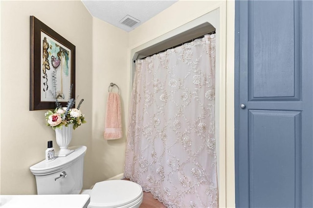 full bath with toilet, curtained shower, and visible vents