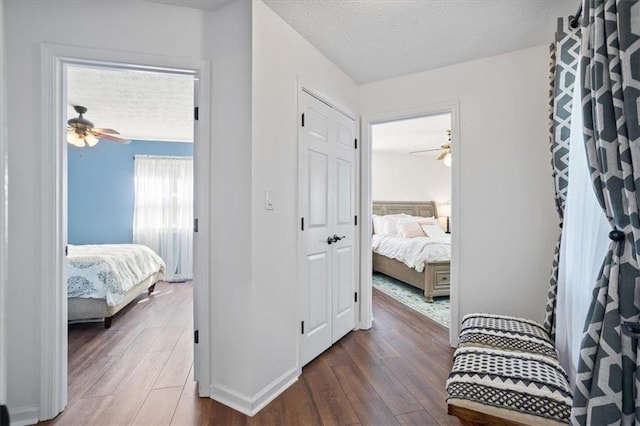 corridor featuring a textured ceiling and wood finished floors