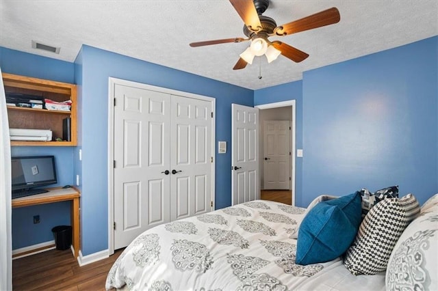 bedroom with a closet, visible vents, a ceiling fan, a textured ceiling, and wood finished floors