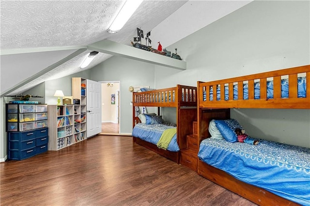 bedroom with vaulted ceiling, a textured ceiling, baseboards, and wood finished floors