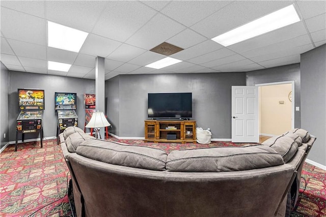 carpeted living area featuring baseboards and a drop ceiling