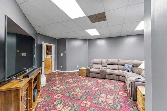 living area with a drop ceiling, carpet flooring, and baseboards