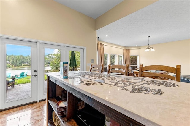 dining room featuring a textured ceiling, french doors, and a chandelier