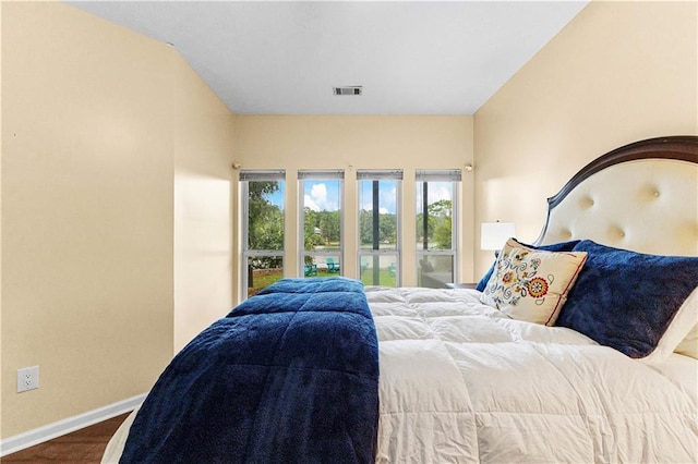 bedroom featuring wood finished floors, visible vents, and baseboards