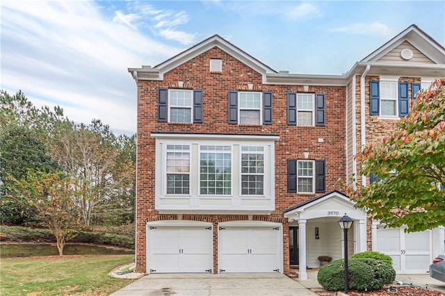 view of property with a garage, brick siding, driveway, and a front lawn