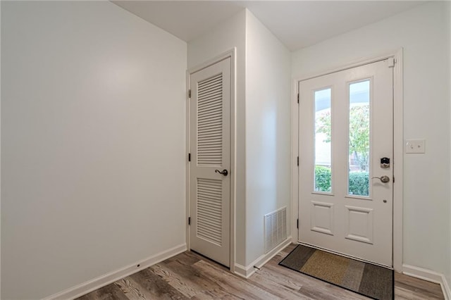 doorway with light wood-type flooring, baseboards, and visible vents