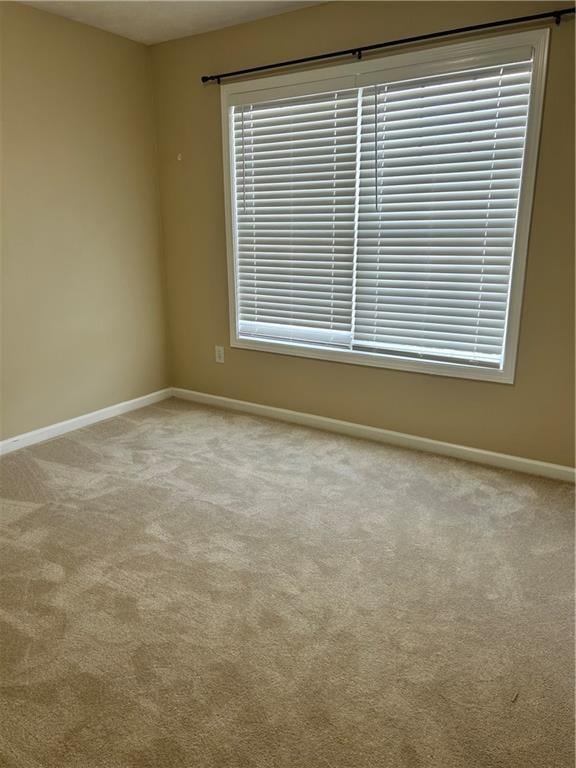 carpeted spare room with baseboards