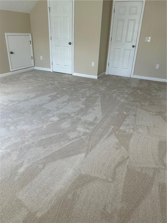 unfurnished bedroom featuring carpet floors and baseboards