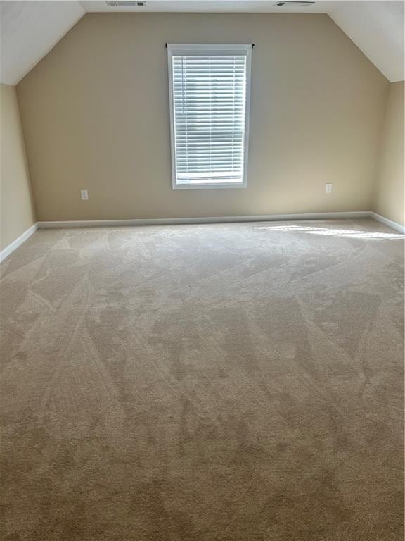 bonus room featuring carpet flooring, vaulted ceiling, and baseboards