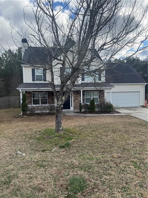 traditional-style home with a porch, an attached garage, fence, driveway, and a front yard