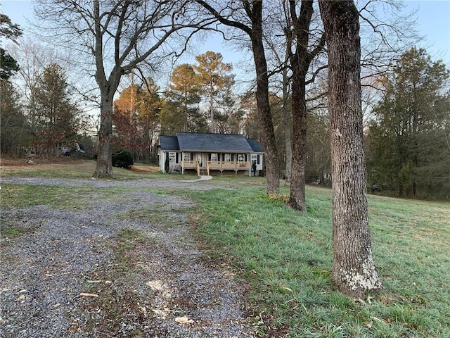 view of front of home featuring a front lawn, driveway, and a wooden deck