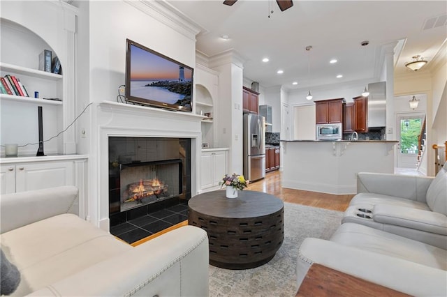 1003 Pearl Pt NE, Sandy Springs, GA 30328 - living area featuring ornamental molding, light wood-style flooring, ceiling fan, built in shelves, and recessed lighting