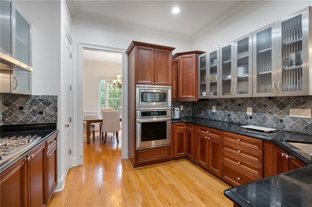 1003 Pearl Pt NE, Sandy Springs, GA 30328 - kitchen with stainless steel appliances, wall chimney range hood, light wood-style floors, ornamental molding, and tasteful backsplash
