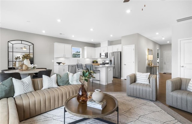 living room featuring a ceiling fan, light wood-style flooring, recessed lighting, and visible vents