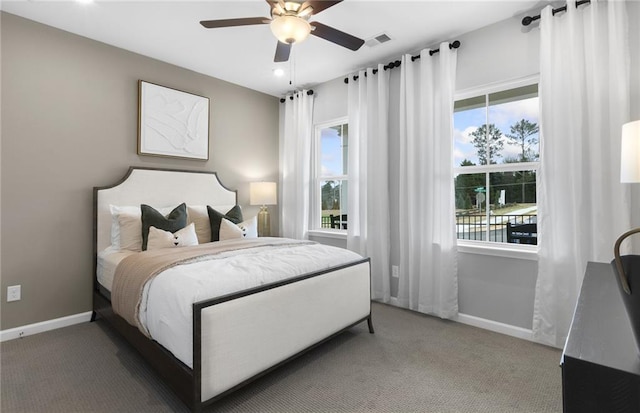 carpeted bedroom with visible vents, baseboards, and ceiling fan