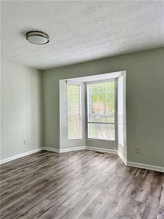 5105 N Bridges Dr, Alpharetta, GA 30022 - unfurnished room with wood finished floors, a textured ceiling, and baseboards