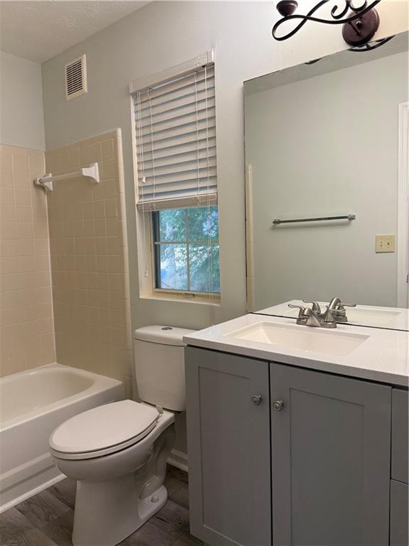 5105 N Bridges Dr, Alpharetta, GA 30022 - full bathroom with toilet, vanity, wood finished floors, and bathtub / shower combination