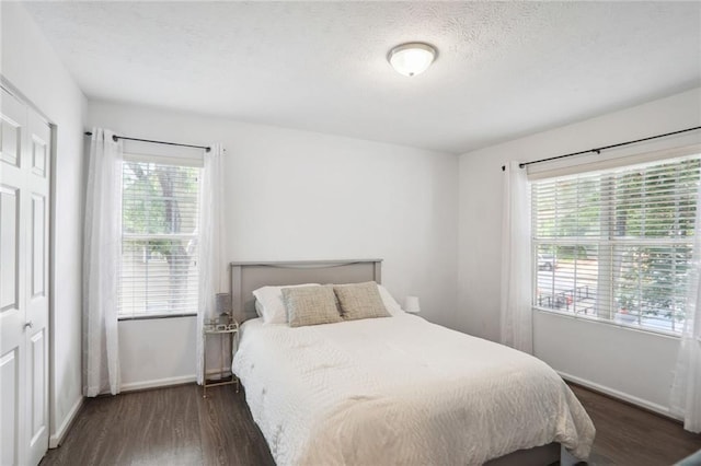 bedroom featuring dark hardwood / wood-style floors and a textured ceiling