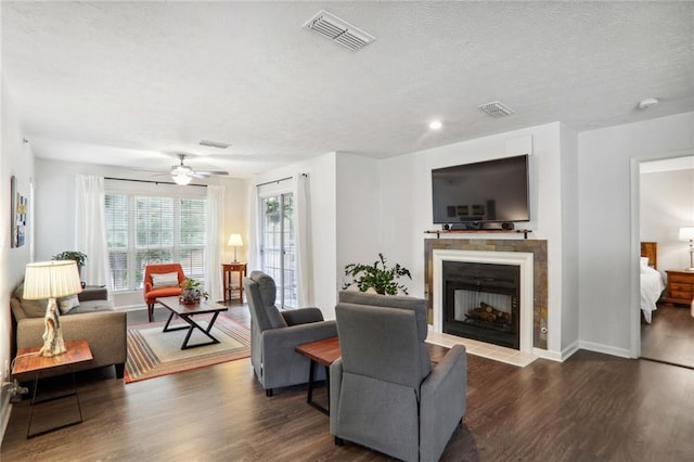 living room featuring ceiling fan, dark hardwood / wood-style flooring, and a textured ceiling