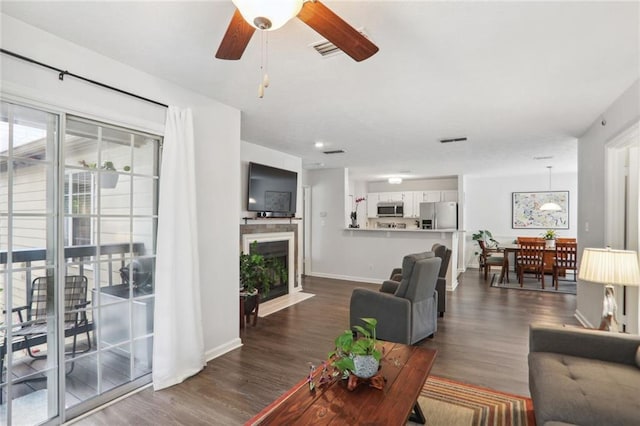 living room with ceiling fan and dark wood-type flooring