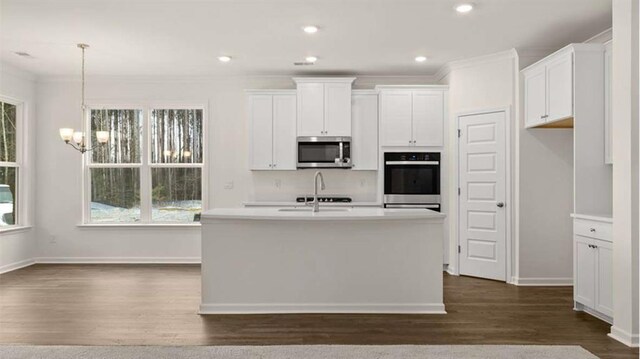 13917 Homer Ln, Covington, GA 30014 - kitchen with white cabinets, stainless steel appliances, dark wood finished floors, a sink, and a notable chandelier