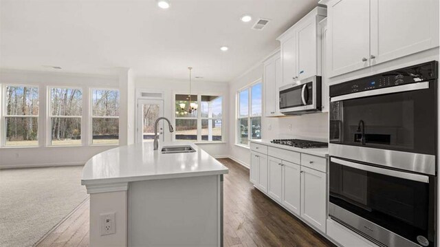 13917 Homer Ln, Covington, GA 30014 - kitchen featuring light countertops, a sink, appliances with stainless steel finishes, a kitchen island with sink, and visible vents