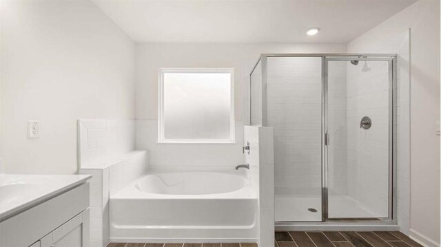 13917 Homer Ln, Covington, GA 30014 - bathroom featuring wood tiled floor, vanity, a garden tub, and a shower stall