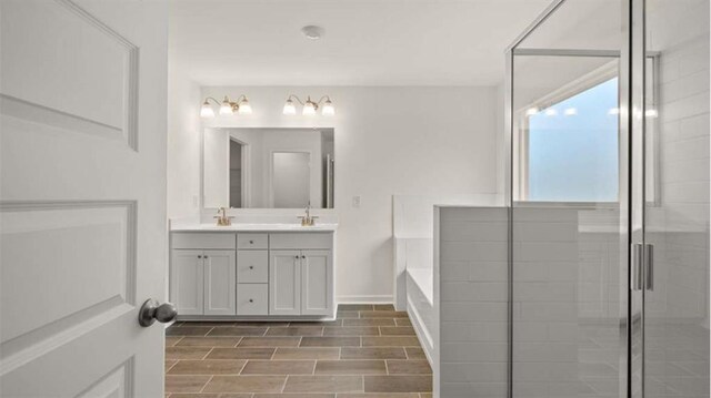 13917 Homer Ln, Covington, GA 30014 - full bathroom featuring a bath, a shower stall, double vanity, a sink, and wood tiled floor