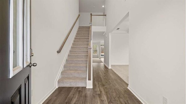 13917 Homer Ln, Covington, GA 30014 - foyer featuring stairs, a high ceiling, baseboards, and dark wood-style floors