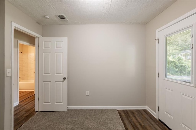 4650 Big Valley Ct, Stone Mountain, GA 30083 - spare room featuring a textured ceiling, baseboards, and dark wood finished floors