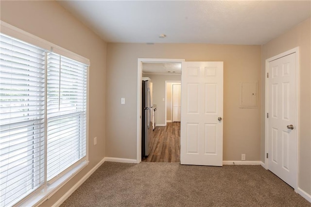4650 Big Valley Ct, Stone Mountain, GA 30083 - unfurnished bedroom featuring freestanding refrigerator, carpet, baseboards, and electric panel