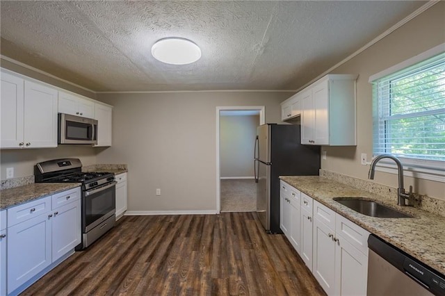 4650 Big Valley Ct, Stone Mountain, GA 30083 - kitchen featuring stainless steel appliances, a sink, crown molding, a textured ceiling, and white cabinets