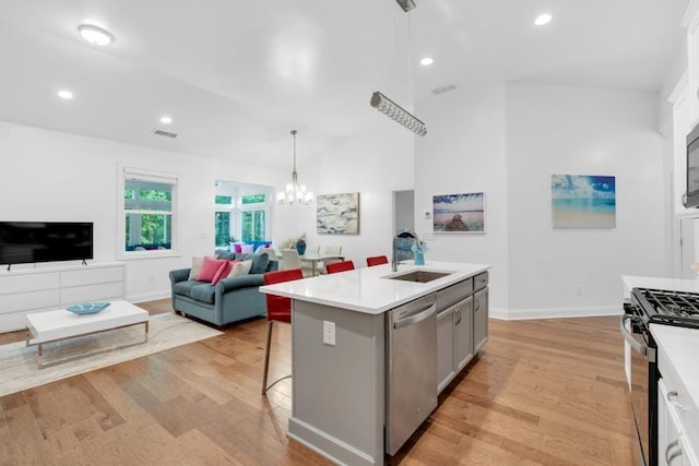 kitchen featuring sink, gas range, a kitchen island with sink, light wood-type flooring, and dishwasher