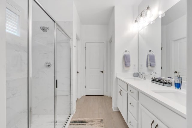 bathroom featuring double vanity, walk in shower, and hardwood / wood-style floors