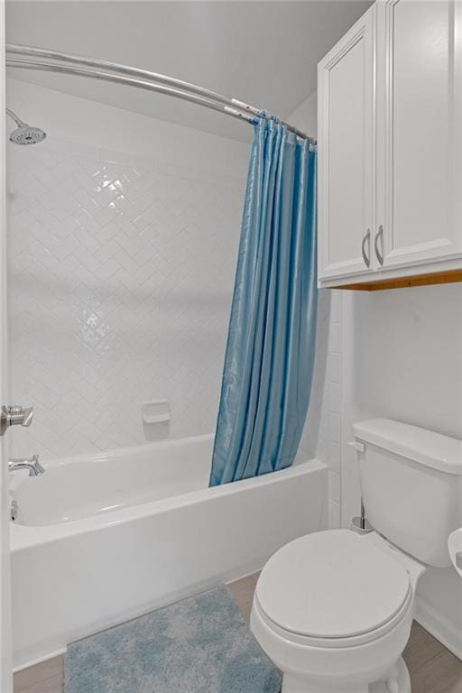 bathroom with toilet, shower / bathtub combination with curtain, and hardwood / wood-style floors