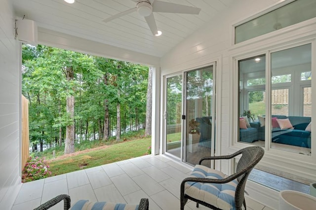 sunroom / solarium with ceiling fan and vaulted ceiling