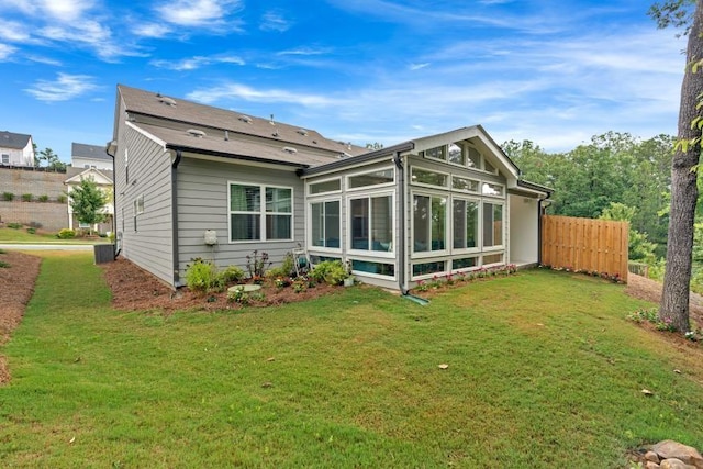 back of house featuring a sunroom and a yard