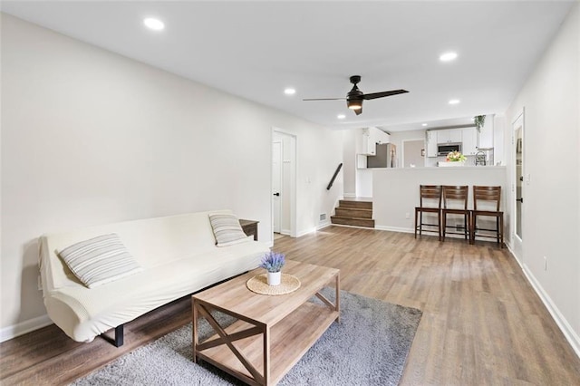 living room with ceiling fan and hardwood / wood-style floors