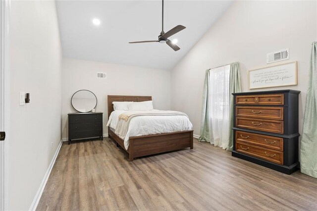 bedroom with ceiling fan, hardwood / wood-style floors, and high vaulted ceiling