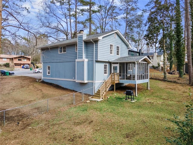 back of property featuring a sunroom and a lawn