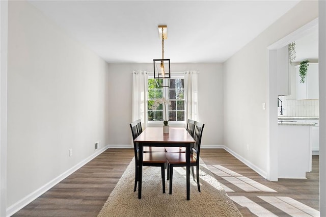 dining room featuring wood-type flooring and a notable chandelier