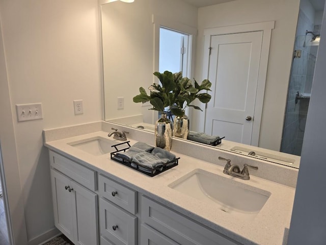 bathroom with tiled shower and vanity