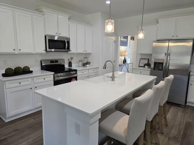 kitchen with a center island with sink, white cabinets, and stainless steel appliances