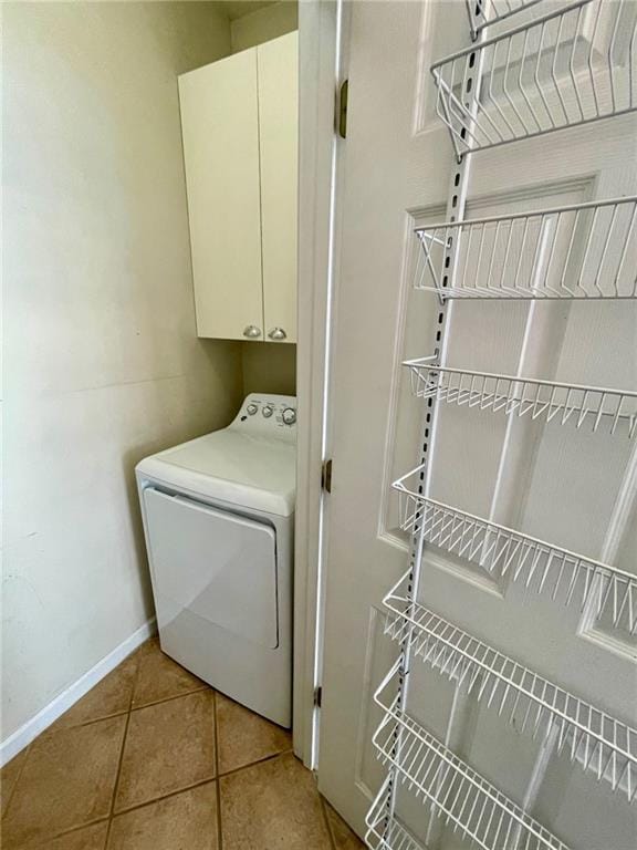 laundry room with cabinets, washer / dryer, and light tile patterned floors