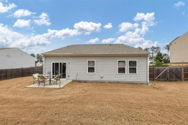 rear view of house with a lawn and a patio