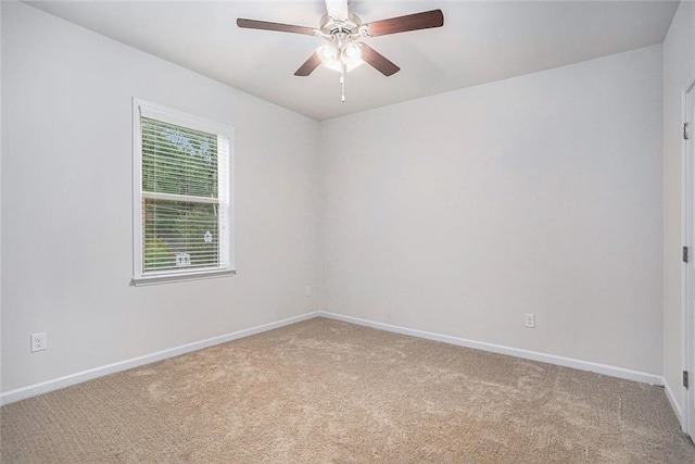 carpeted spare room featuring ceiling fan