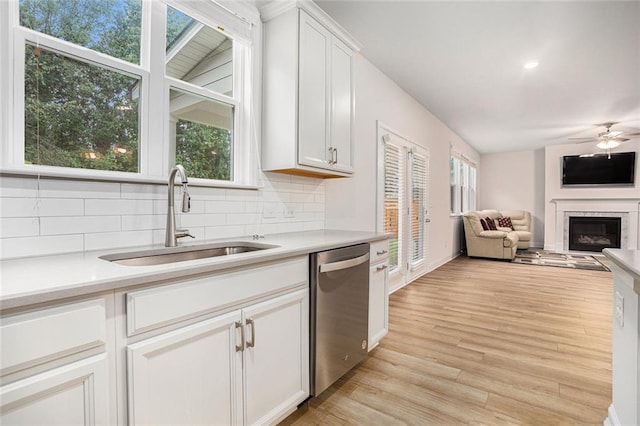 kitchen featuring sink, dishwasher, white cabinetry, and plenty of natural light