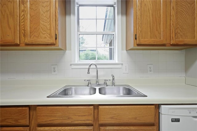 kitchen featuring tasteful backsplash, dishwasher, and sink